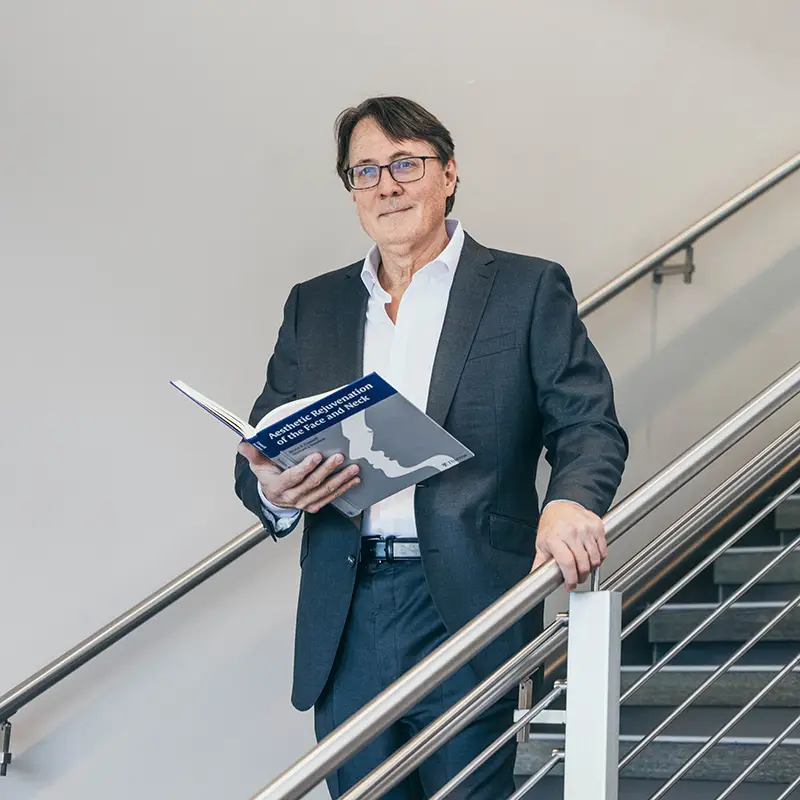 Dr. Sundine on stairs holding book